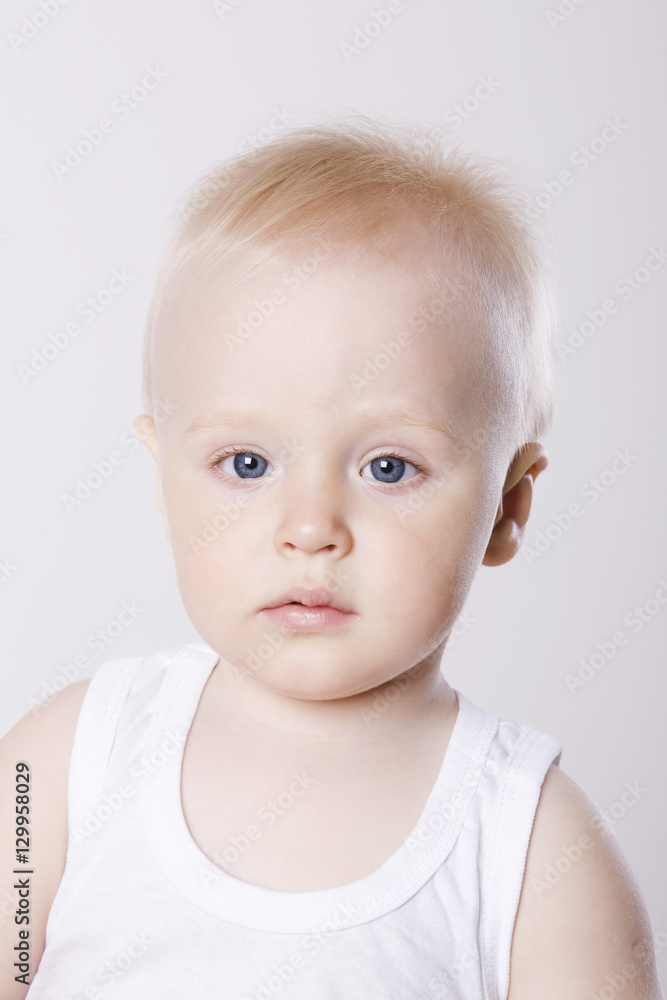 Closeup portrait of a cute baby boy against white background