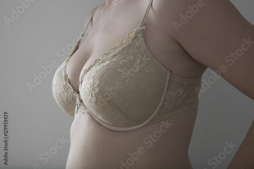 Midsection of a sensual woman in lingerie against gray background