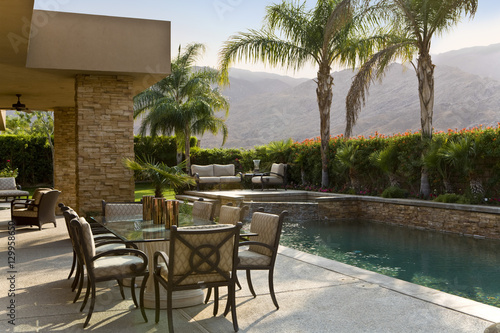 Chairs around outdoor table by the swimming pool © moodboard