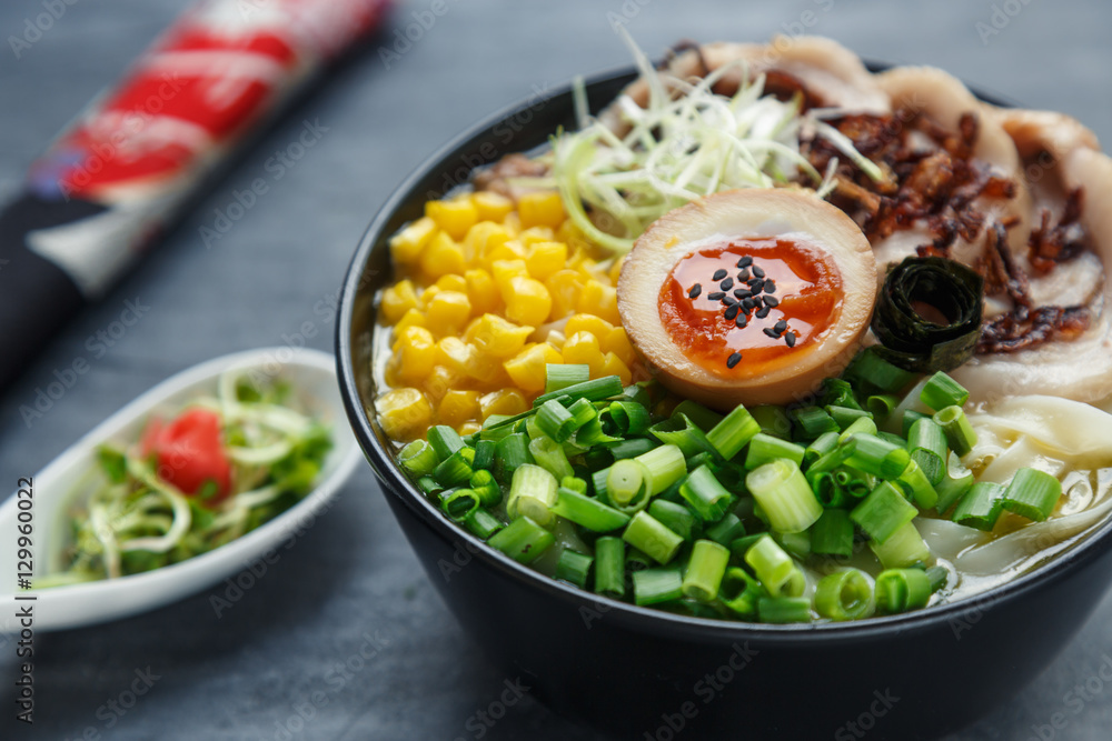 tonkotsu ramen, japanese noodle soup with pork belly, corn, spring onion and nitamago on top