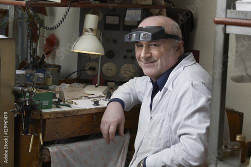 Portrait of smiling senior watch repairman in workshop