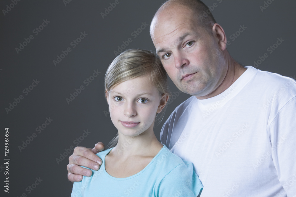 Portrait of a father with his young daughter against gray background Portrait of a father with his young daughter against gray background