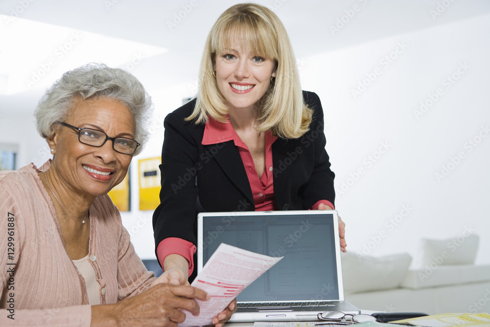 Portrait of Caucasian female financial advisor assisting senior woman Portrait of Caucasian female financial advisor assisting senior woman