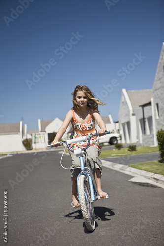 Full length portrait of a young girl riding bicycle on street