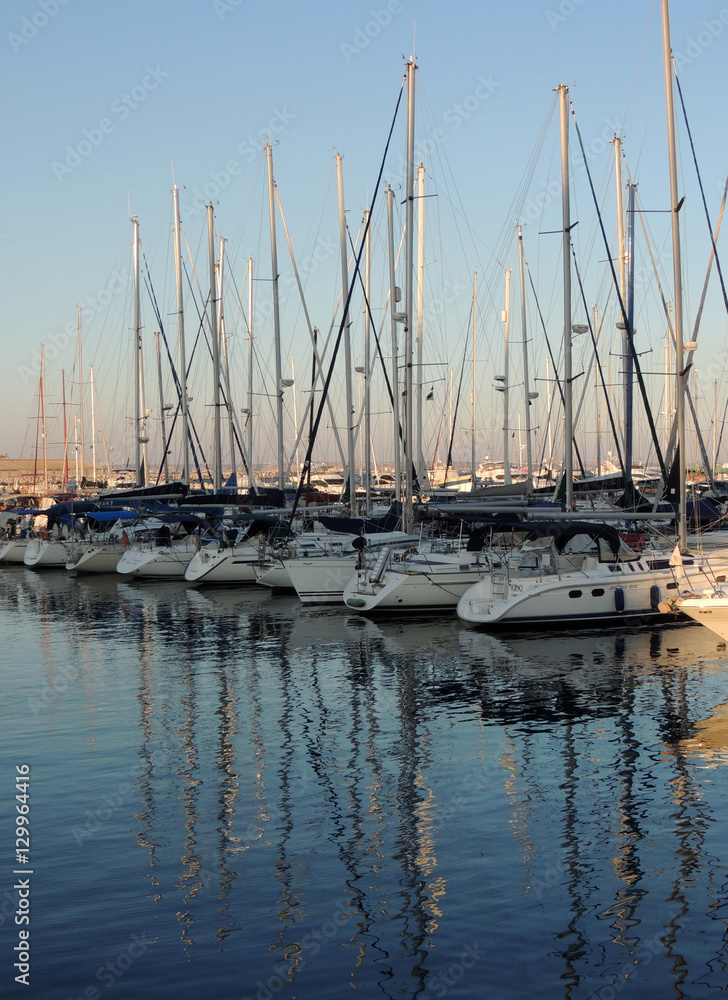 Wintering of yachts in the port. Reflections in the water