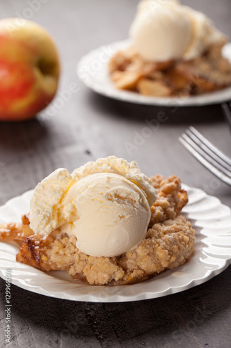 Large dish of apple crisp with vanilla ice cream on top