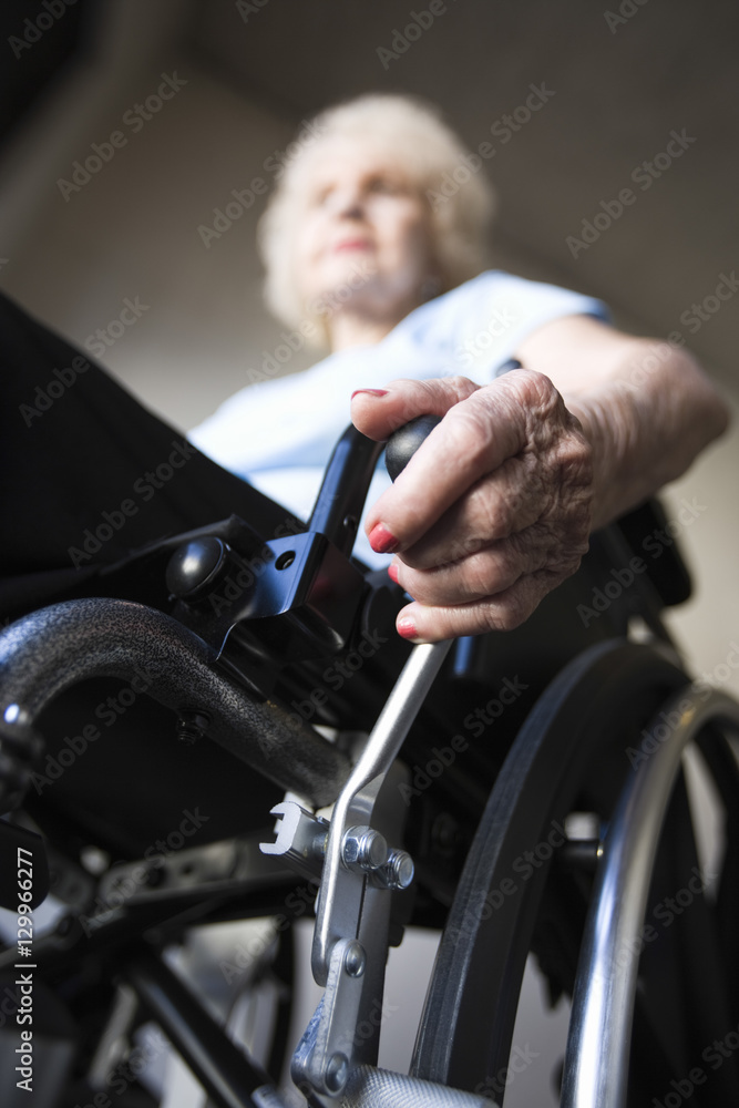 Low angle view of a blurred senior woman operating wheelchair Low angle view of a blurred senior woman operating wheelchair