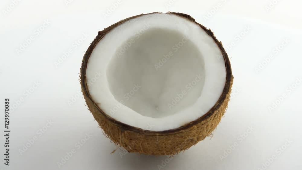 One half of a ripe tropical coconut rotating on a white background. Tropical fruits. Loopable. One half of a ripe tropical coconut rotating on a white background. Tropical fruits. Loopable.
