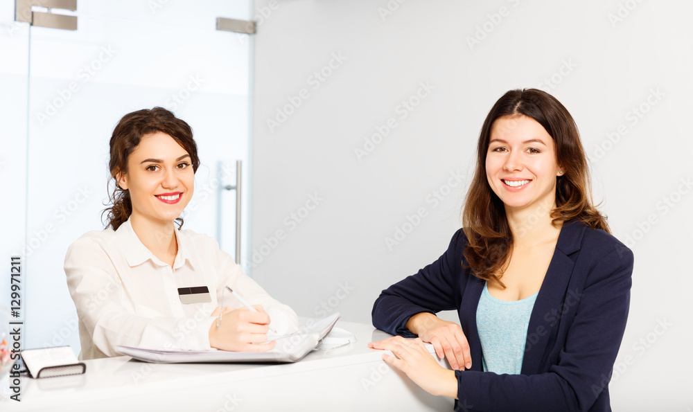 friendly woman behind reception desk administrator with customer friendly woman behind reception desk administrator with customer