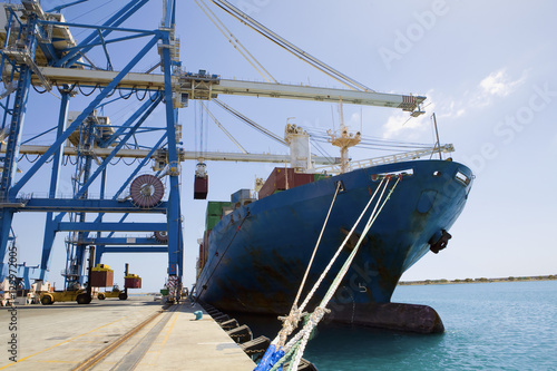 Cranes by cargo containers in ship against the sky at dock in Limassol Cyprus