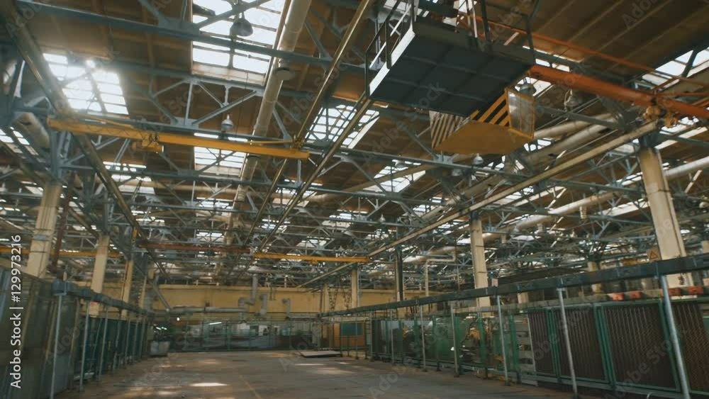 Production premise with a high ceiling and a large number of industrial equipment throughout the territory. Many metal structures, ventilation pipes used in building construction. Big light windows in Production premise with a high ceiling and a large number of industrial equipment throughout the territory. Many metal structures, ventilation pipes used in building construction. Big light windows in