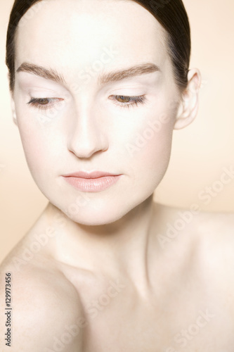 Closeup of a young woman with fresh skin against colored background © moodboard