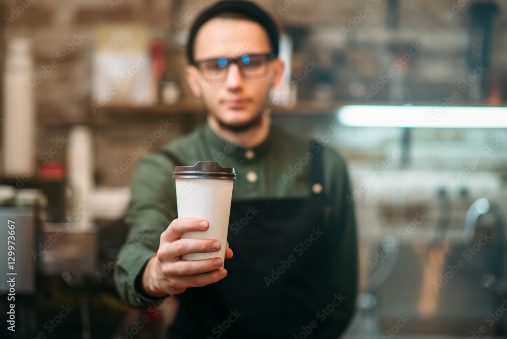 Barman in black apron stretches plastic cup