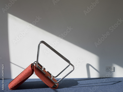 Side view of an upturned office chair casting shadow on wall