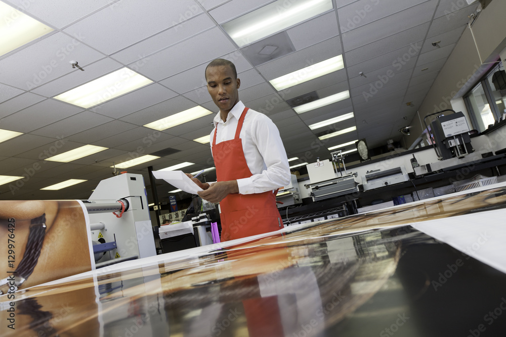 Manual worker looking down at prints Manual worker looking down at prints