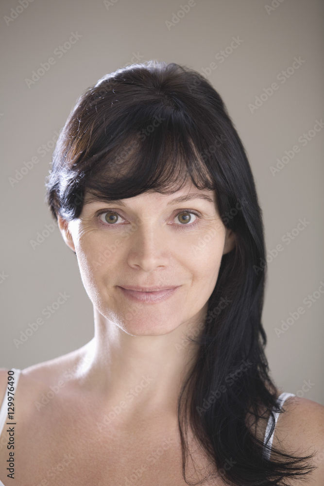 Closeup portrait of a young woman against gray background Closeup portrait of a young woman against gray background