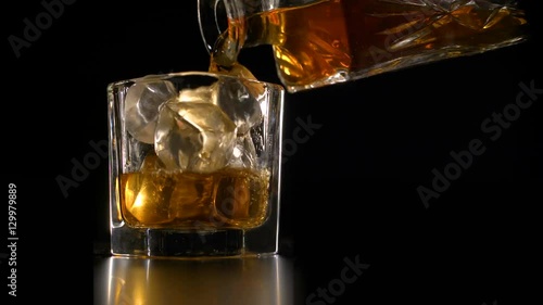 Whiskey on the rocks poured from a rystal decanter photo