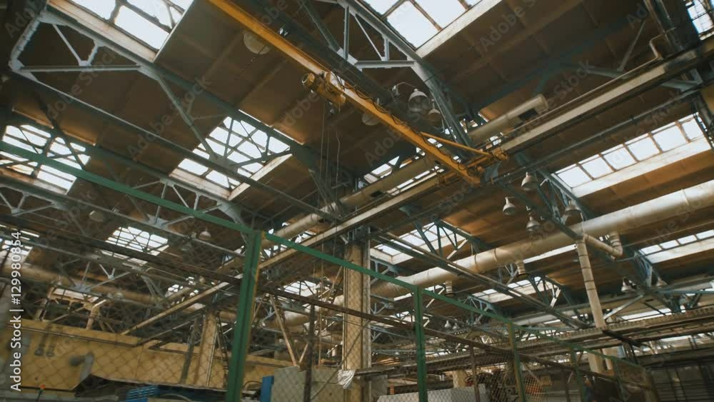 Production premise with a high ceiling and a large number of industrial equipment throughout the territory. Many metal structures, ventilation pipes used in building construction. Big light windows in Production premise with a high ceiling and a large number of industrial equipment throughout the territory. Many metal structures, ventilation pipes used in building construction. Big light windows in