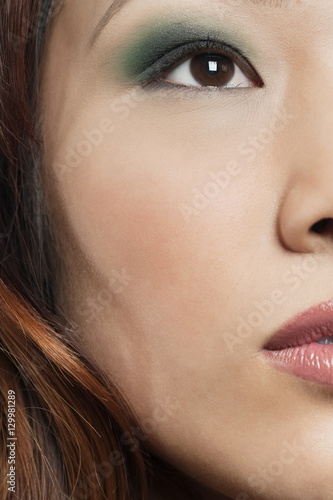 Cropped image of beautiful Chinese woman with makeup looking away