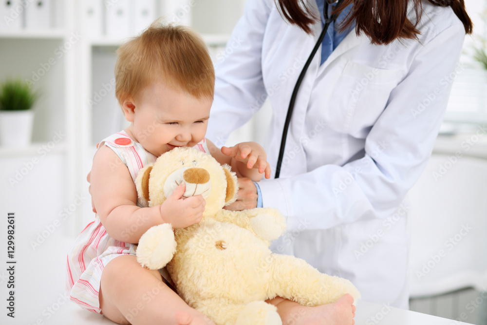 Happy cute baby at health exam at doctor's office. Medicine and health care concept Happy cute baby at health exam at doctor's office. Medicine and health care concept