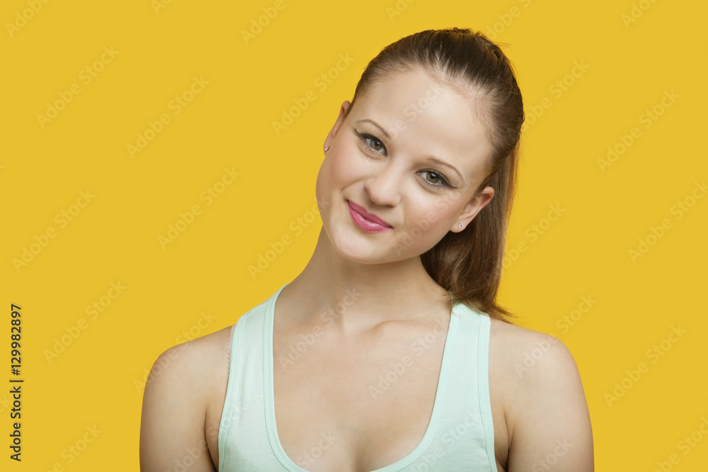 Portrait of beautiful young woman smiling over yellow background Portrait of beautiful young woman smiling over yellow background