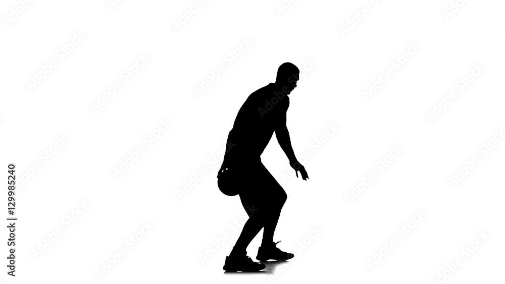 Basketball moves and stuffing the ball under his foot. Side view. Silhouette Basketball moves and stuffing the ball under his foot. Side view. Silhouette