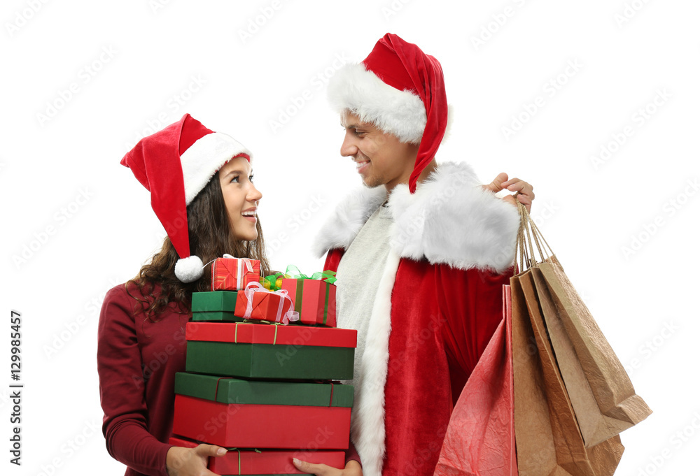 Young couple with Christmas purchases on white background Young couple with Christmas purchases on white background