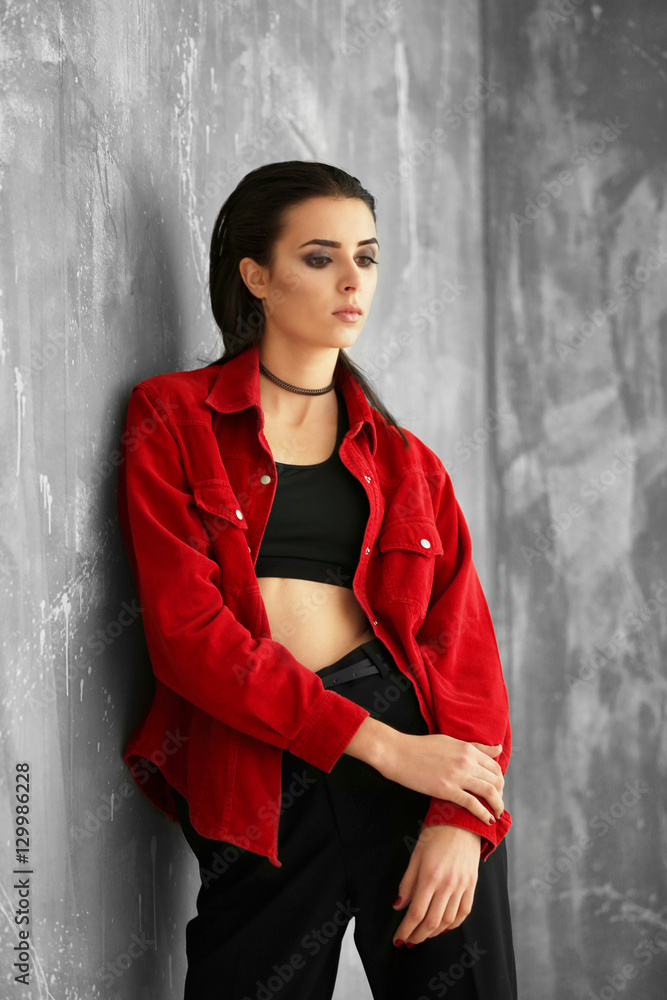 Beautiful woman in fashion clothes on grunge wall background Beautiful woman in fashion clothes on grunge wall background