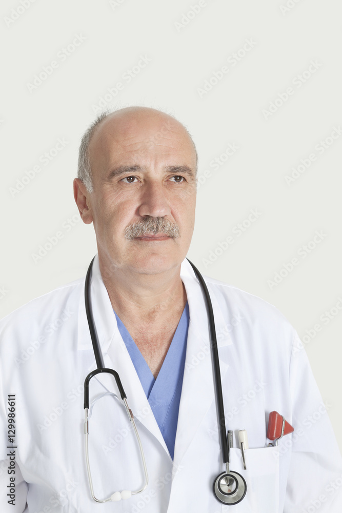 Senior male doctor with stethoscope over gray background Senior male doctor with stethoscope over gray background
