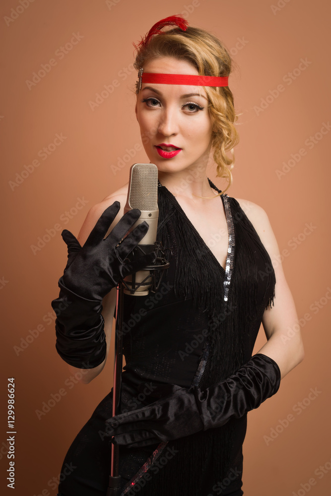 Pretty actress in black retro dress singing with microphone Pretty actress in black retro dress singing with microphone