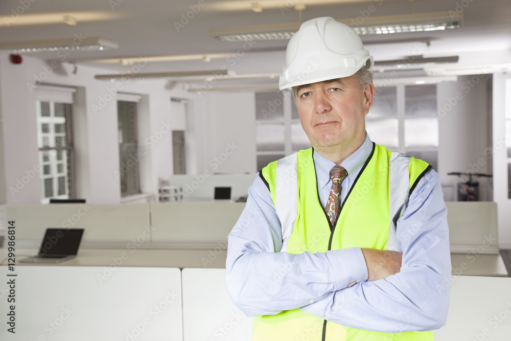 Portrait of middle-aged man in reflector vest and hard hat at office Portrait of middle-aged man in reflector vest and hard hat at office