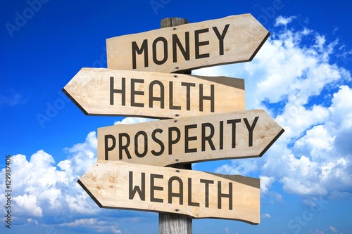 Wooden signpost with four arrows - money, health, prosperity, wealth - great for topics like business, work balance etc. photo