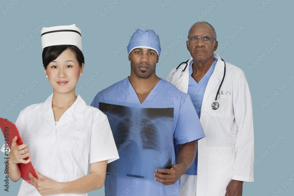 Portrait of three multi ethnic medical professionals over light blue background