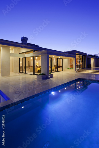 Rear view of luxury villa at night time with swimming pool © moodboard