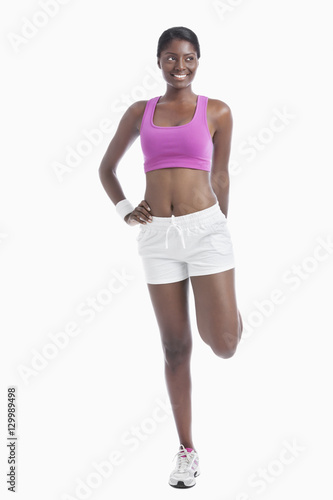 Young African American woman exercising over white background © moodboard