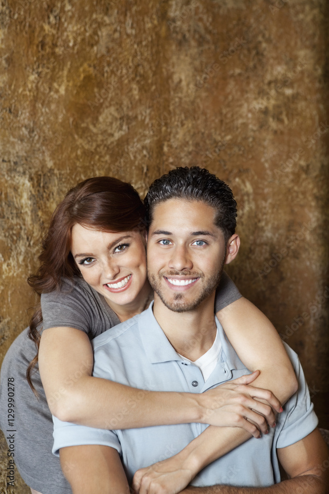 Portrait of happy young woman hugging man from behind Portrait of happy young woman hugging man from behind