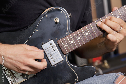 Close-up view of man playing electric guitar
