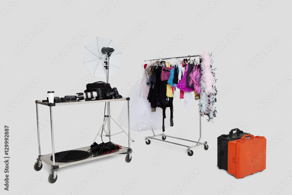 Clothes rack and reflector umbrella with suitcase in studio Clothes rack and reflector umbrella with suitcase in studio