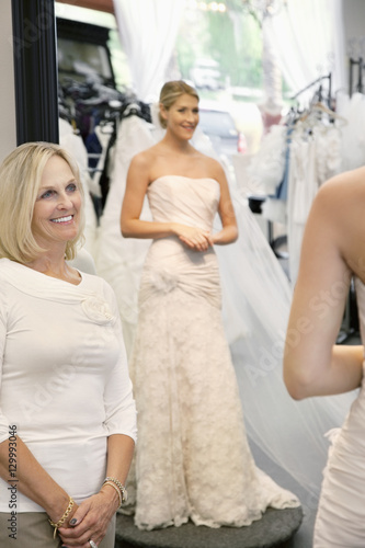 Happy mother admiring daughter dressed in a wedding gown
