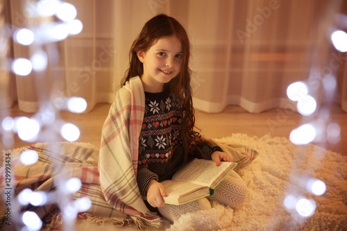 Cute little girl reading bo...