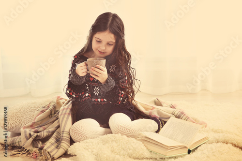 Cute little girl sitting on...