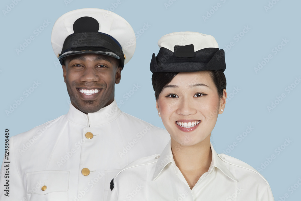 Portrait of multi-ethnic US Navy officers smiling over light blue background Portrait of multi-ethnic US Navy officers smiling over light blue background