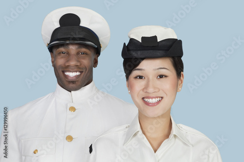 Portrait of multi-ethnic US Navy officers smiling over light blue background photo