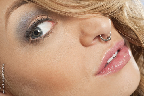 Cropped image of beautiful young woman with nose ring looking sideways