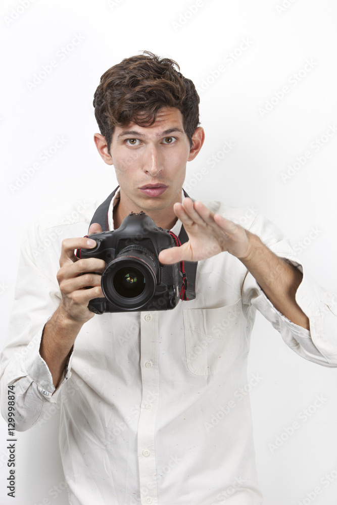 Fototapeta premium Portrait of young photographer with vintage camera gesturing against white background