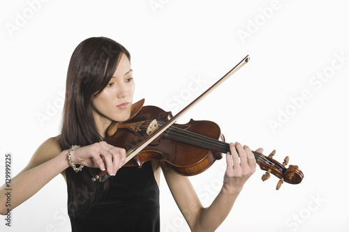 Young woman playing violin isolated over white background