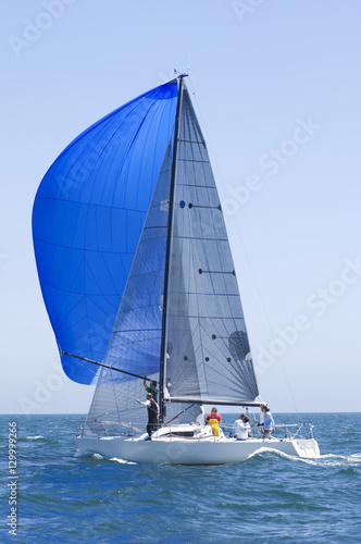 View of a yacht with blue sail competing in team sailing event