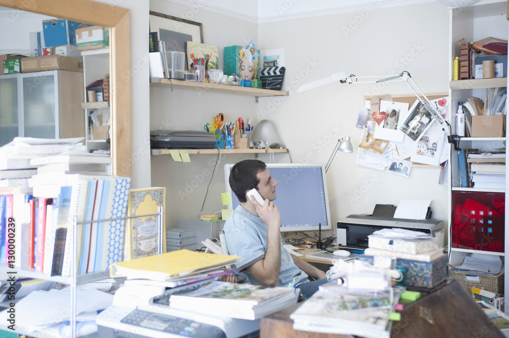 Side view of businessman using landline phone in creative office space Side view of businessman using landline phone in creative office space