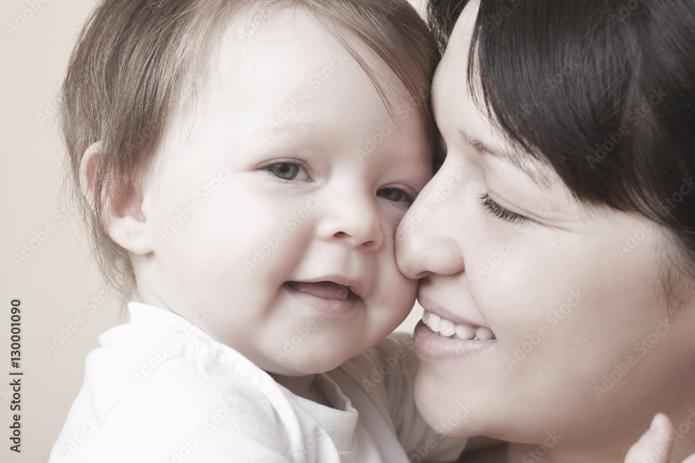 Closeup of happy mother caressing baby girl over colored background Closeup of happy mother caressing baby girl over colored background