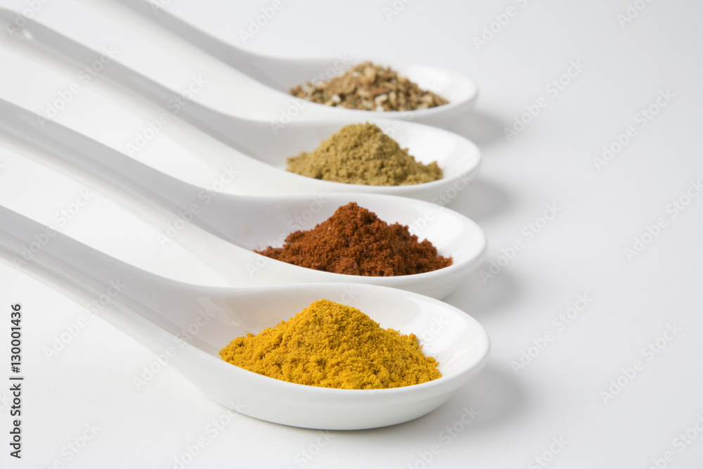 Closeup of spices in spoons isolated over white background Closeup of spices in spoons isolated over white background